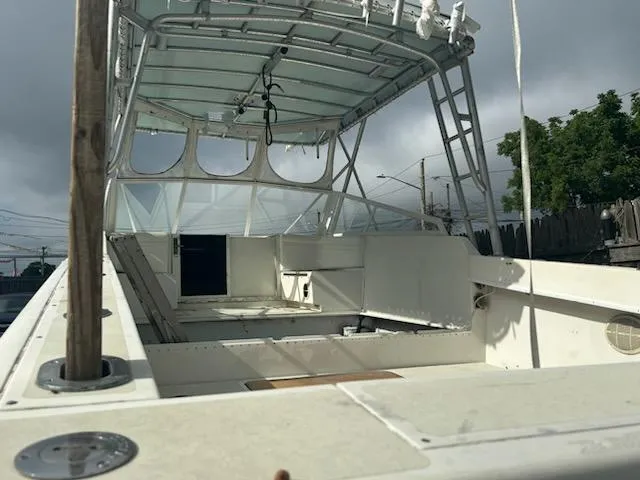 Slide: The Image of 1998 Contender 35 Express boat with open deck and canopy under cloudy sky. - 5