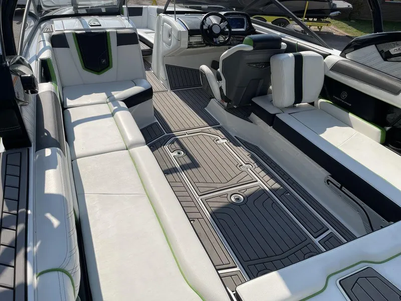 Slide: The Image of 2016 Nautique G25 boat interior with white and black seating, modern dashboard, and spacious layout. - 5