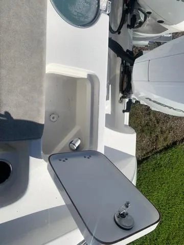 Slide: The Image of 2024 Sea Pro 262 CC boat interior, featuring storage compartment and seating area. - 13