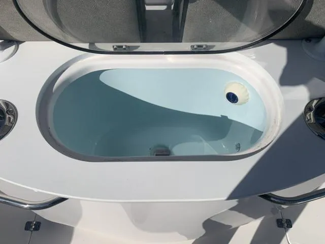 Slide: The Image of 2024 Sea Pro 262 CC boat livewell with open lid, showcasing interior. - 27