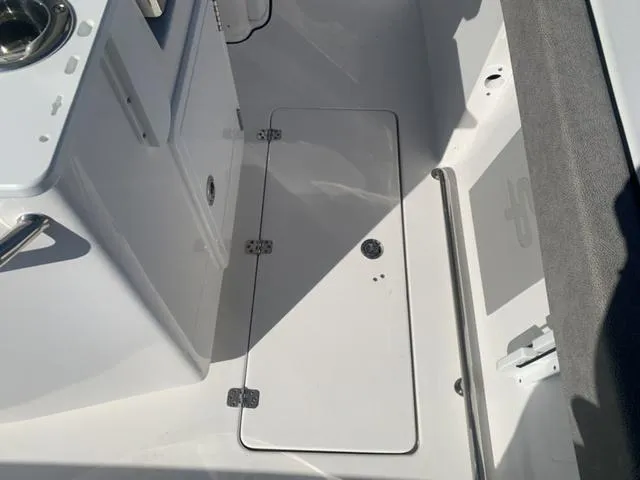 Slide: The Image of 2024 Sea Pro 262 CC boat interior, featuring storage compartment and sleek design. - 28
