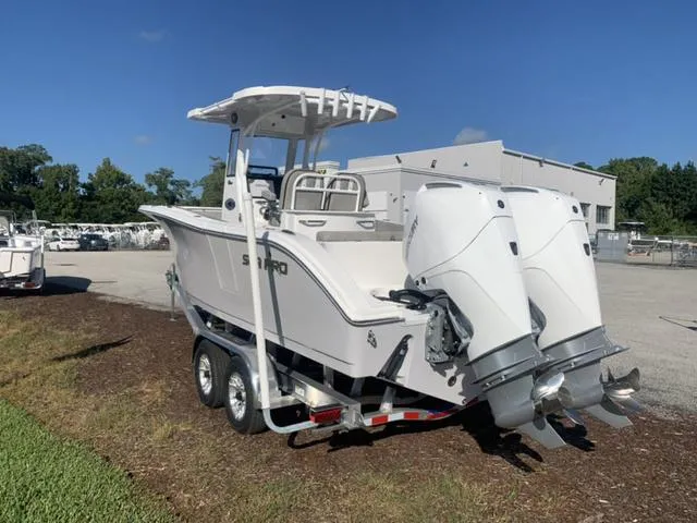 Slide: The Image of 2024 Sea Pro 262 CC boat with dual engines on a trailer, parked outdoors. - 3
