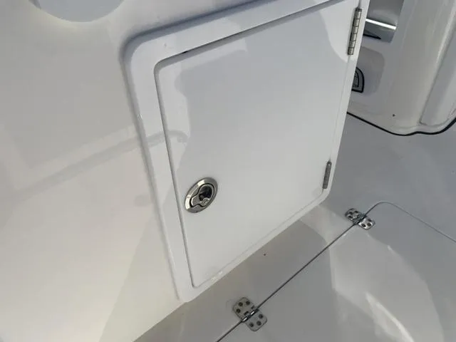 Slide: The Image of 2024 Sea Pro 262 CC boat storage compartment with secure latch. - 30