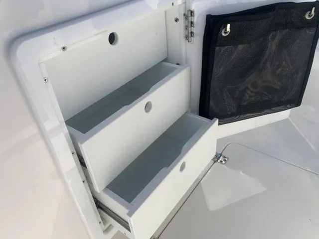 Slide: The Image of 2024 Sea Pro 262 CC storage compartment with open drawers and mesh pocket. - 31