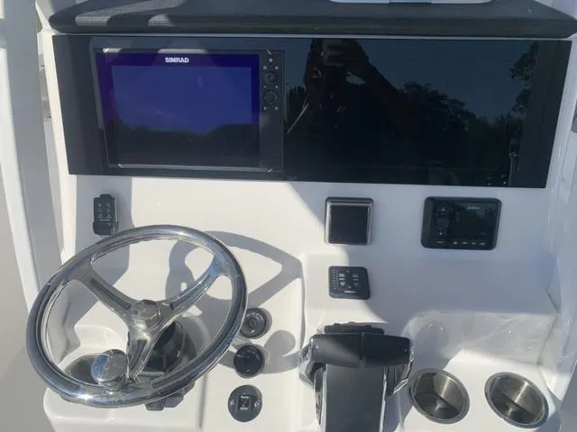 Slide: The Image of 2024 Sea Pro 262 CC boat dashboard with steering wheel and navigation display. - 32