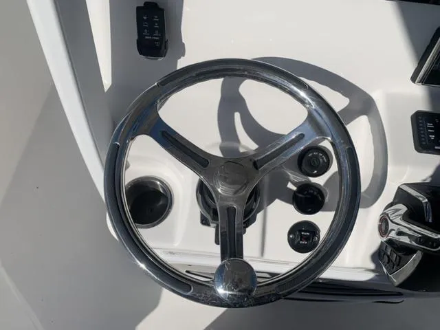 Slide: The Image of 2024 Sea Pro 262 CC steering wheel and controls, close-up view. - 35