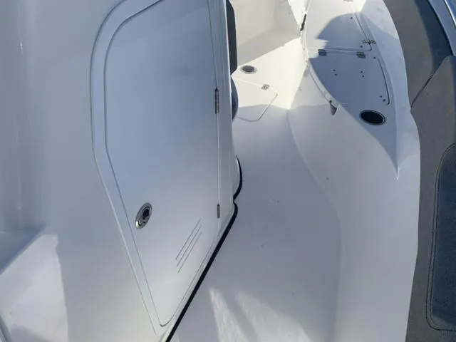 Slide: The Image of 2024 Sea Pro 262 CC boat interior with sleek white design and storage compartment. - 45