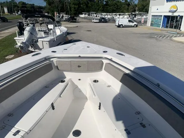 Slide: The Image of 2024 Sea Pro 262 CC boat interior, spacious deck, and seating area in a marina setting. - 48