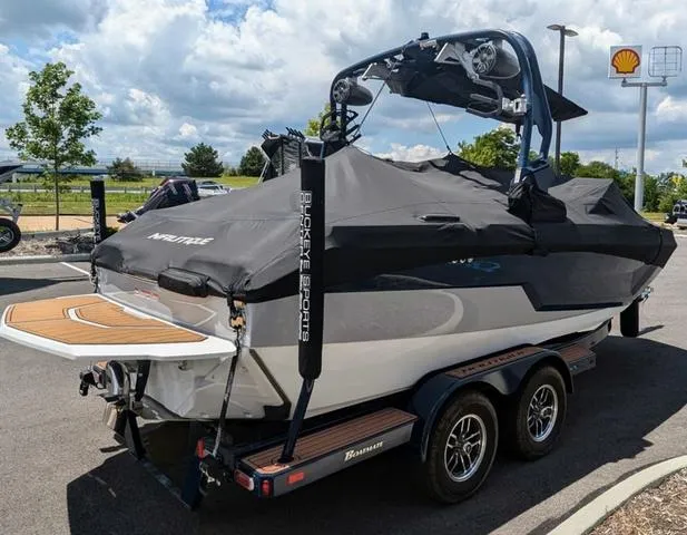 Slide: The Image of 2023 Nautique Super Air Nautique GS20 boat on a trailer, covered and parked outdoors. - 11