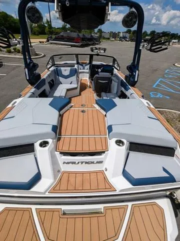 Slide: The Image of 2023 Nautique Super Air Nautique GS20 boat interior with teak flooring and blue-gray seating. - 14