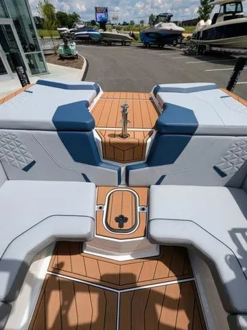 Slide: The Image of 2023 Nautique Super Air Nautique GS20 boat interior with cushioned seating and teak flooring. - 18