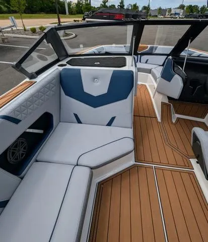 Slide: The Image of 2023 Nautique Super Air Nautique GS20 interior with white and blue seating, teak flooring. - 25