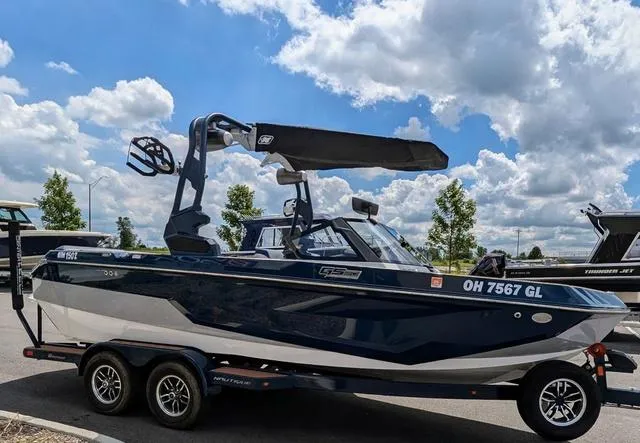 Slide: The Image of 2023 Nautique Super Air Nautique GS20 boat on trailer under a partly cloudy sky. - 7
