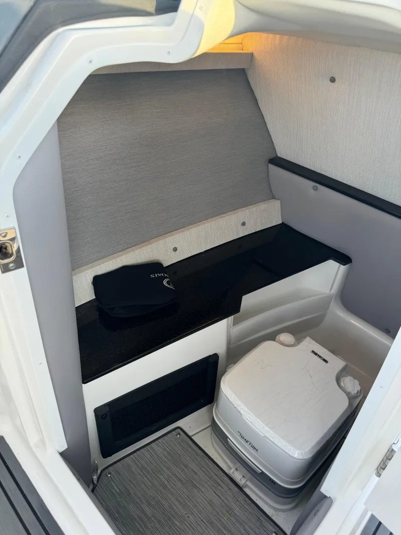 Slide: The Image of 2022 Cobalt R6 Surf boat interior with compact toilet and storage area. - 47