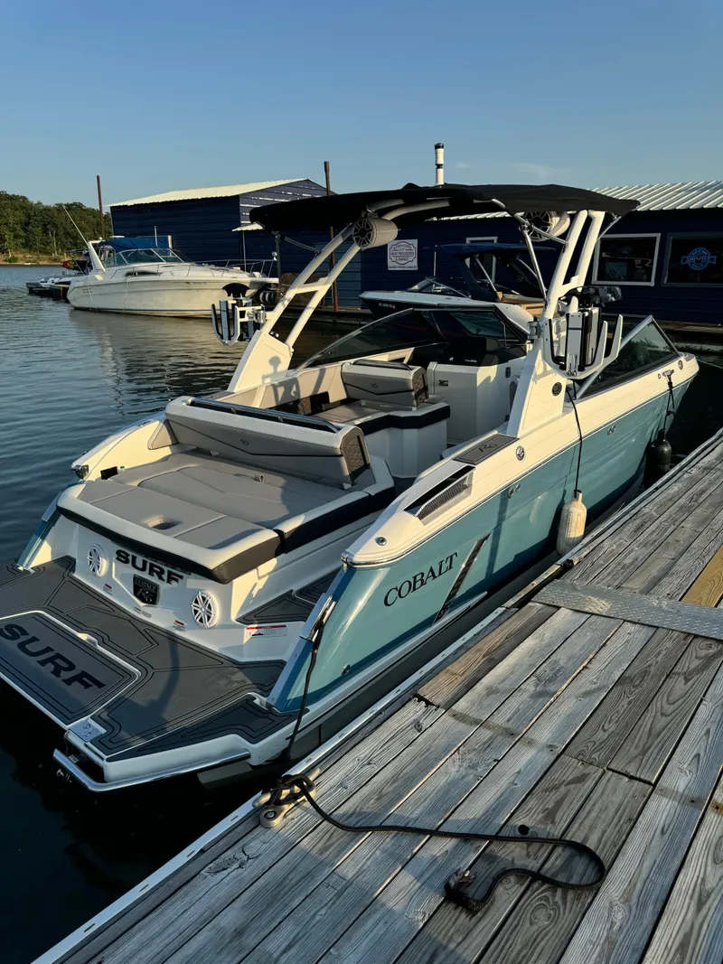 Slide: The Image of 2022 Cobalt R6 Surf boat docked at marina, featuring sleek design and spacious seating. - 48