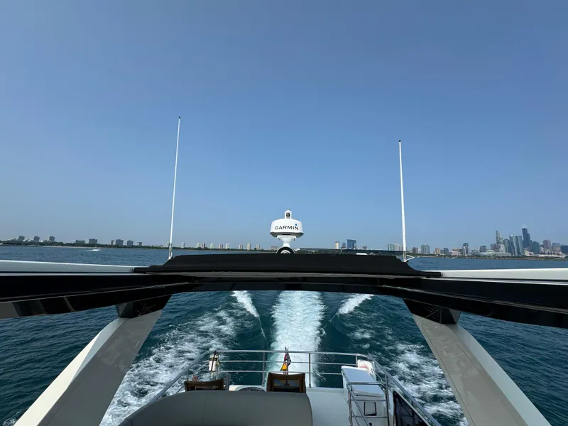 Slide: The Image of Absolute 52 Navetta 2023 yacht cruising with city skyline in background. - 29