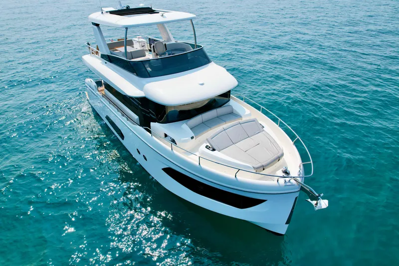 Slide: The Image of 2023 Absolute 52 Navetta yacht cruising on clear blue water. - 2