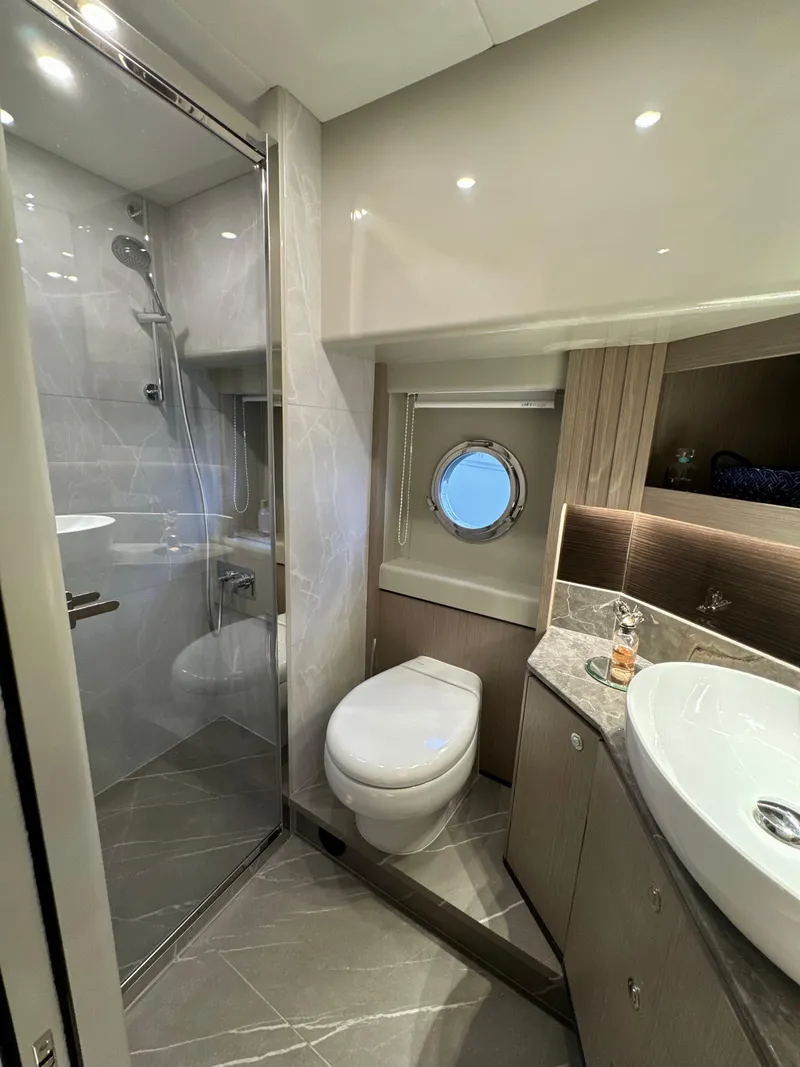 Slide: The Image of Luxurious bathroom in 2023 Absolute 52 Navetta yacht with modern fixtures and porthole window. - 24