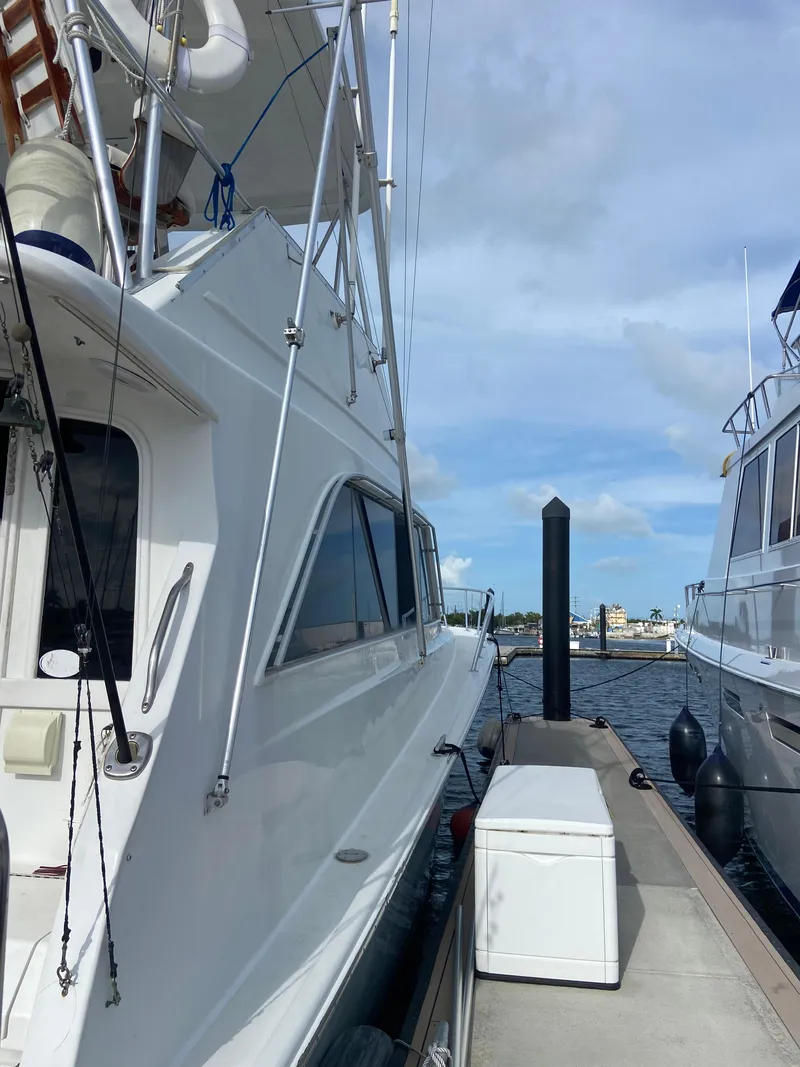 Slide: The Image of 1988 Ocean Yachts 55 Super Sport docked at marina under blue sky. - 2