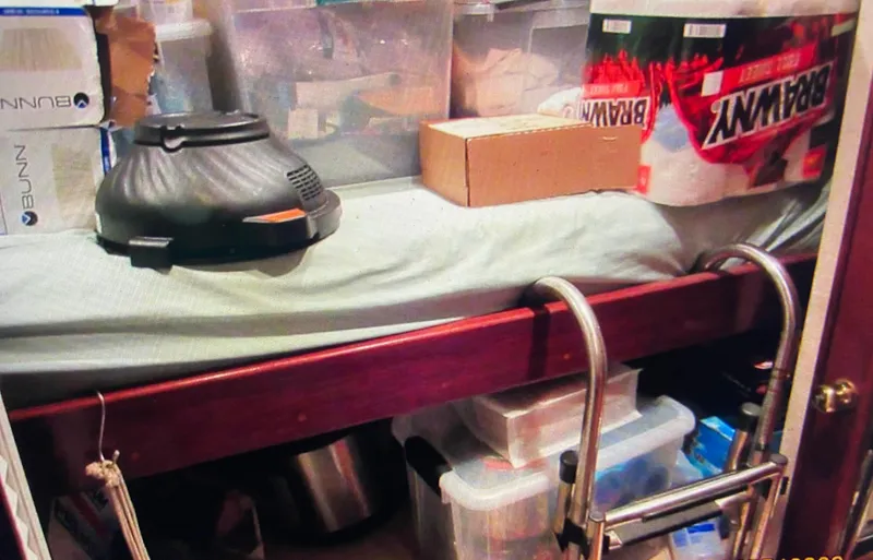 Slide: The Image of Storage area inside 1988 Ocean Yachts 55 Super Sport, featuring various boxes and equipment. - 32