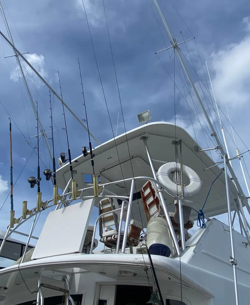 Slide: The Image of 1988 Ocean Yachts 55 Super Sport with fishing rods against a cloudy sky. - 6