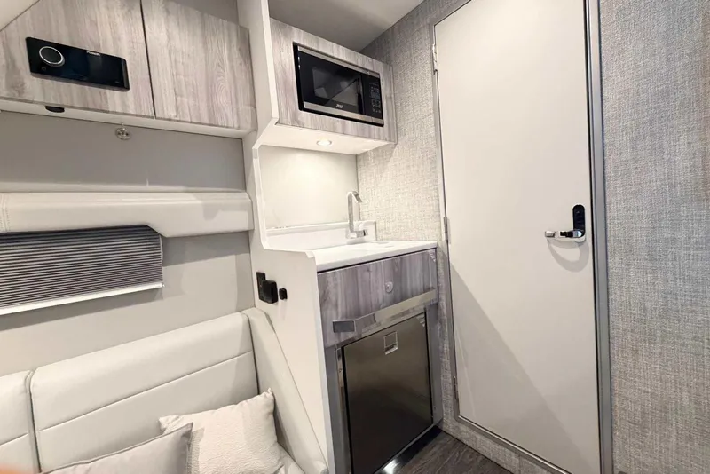 Slide: The Image of 2025 Formula 387 Center Console Fish cabin interior with modern kitchenette and seating area. - 84