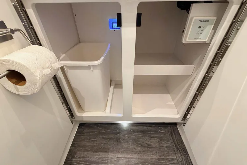 Slide: The Image of 2025 Formula 387 Center Console Fish interior storage with trash bin and toilet paper holder. - 88