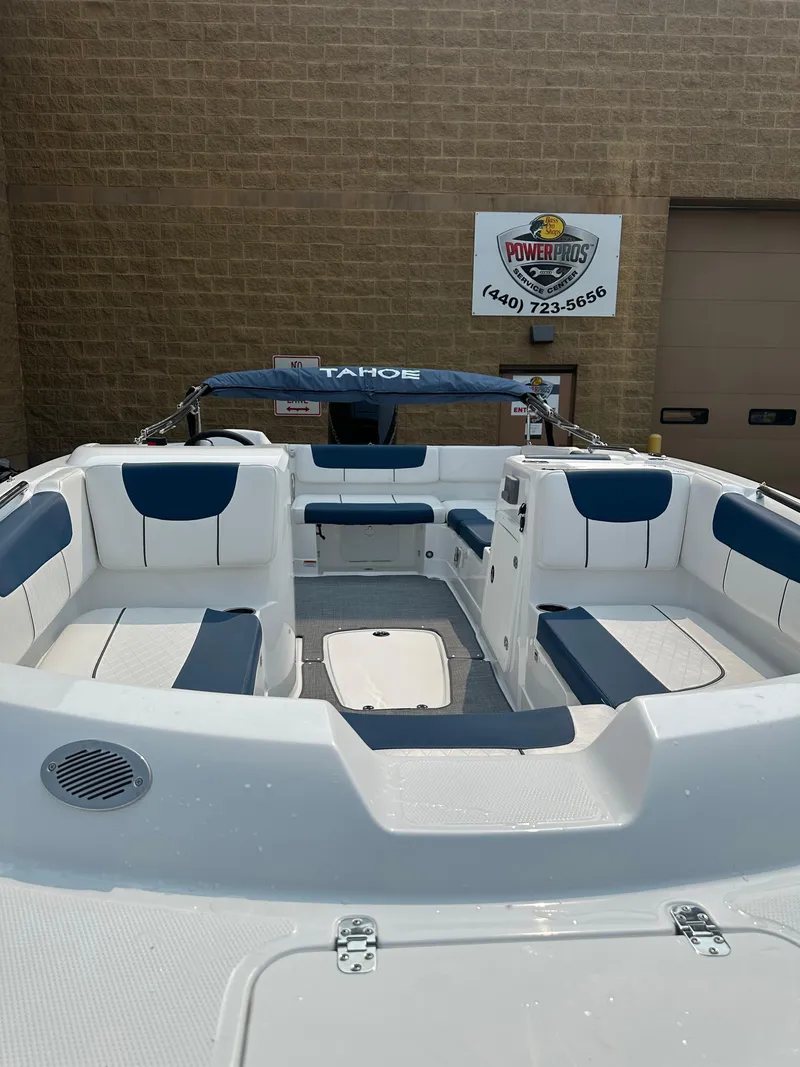 Slide: The Image of 2024 Tahoe 2150 boat with blue and white seating, displayed outdoors. - 5