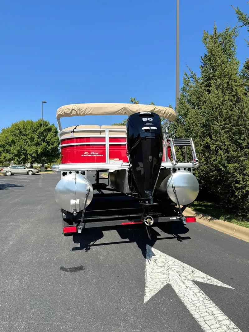 Slide: The Image of 2024 Sun Tracker Party Barge 20 DLX pontoon boat on trailer, parked outdoors. - 5