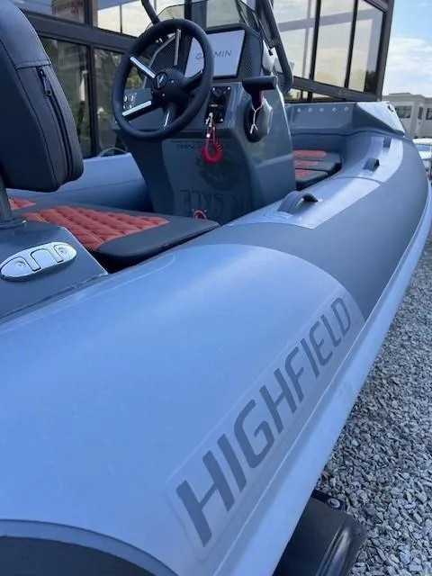 Slide: The Image of 2023 Highfield Sport 390 boat, sleek design, modern interior, steering wheel, and controls visible. - 1