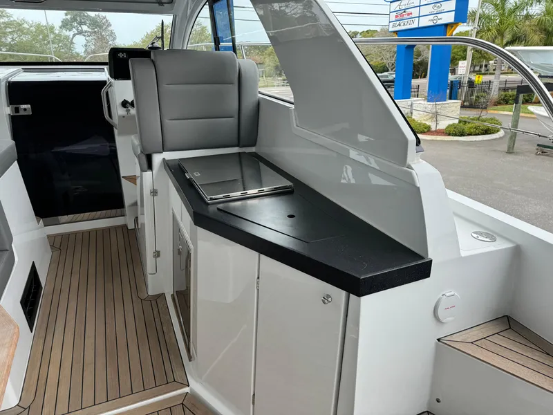 Slide: The Image of 2024 Sealine S335V yacht interior with sleek seating and modern kitchenette. - 12