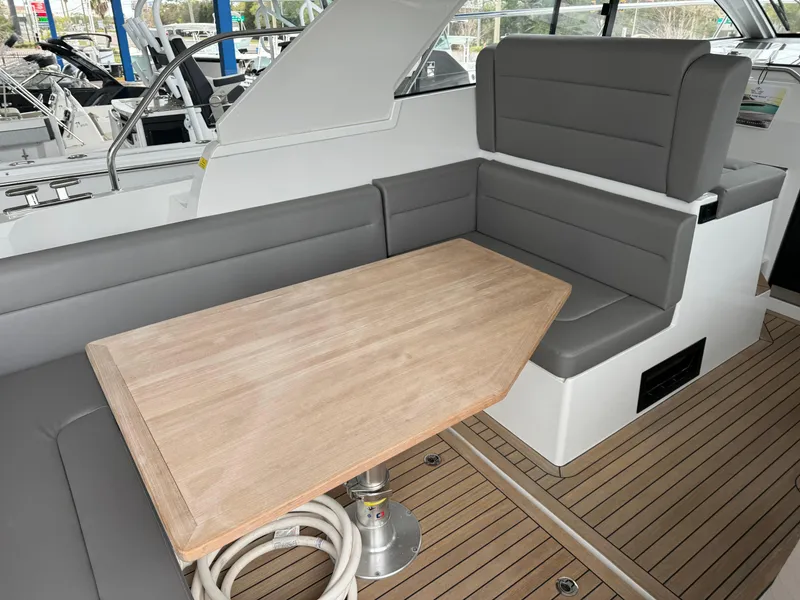 Slide: The Image of 2024 Sealine S335V yacht interior with gray seating and wooden table. - 13