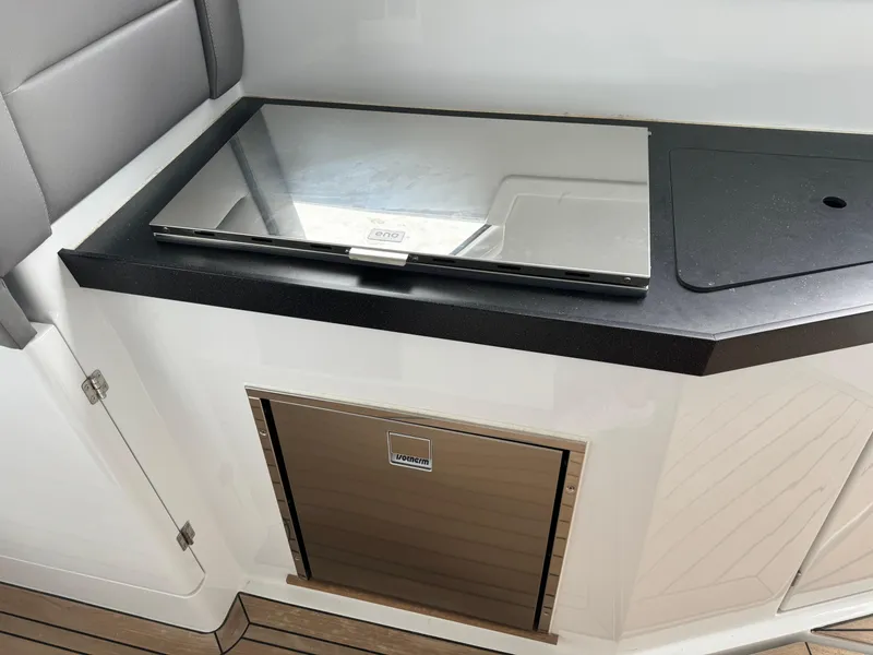 Slide: The Image of 2024 Sealine S335V yacht interior with sleek kitchenette and modern appliances. - 14
