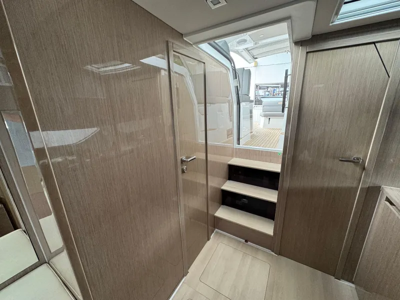 Slide: The Image of 2024 Sealine S335V yacht interior with modern wood finish and steps leading to deck. - 22