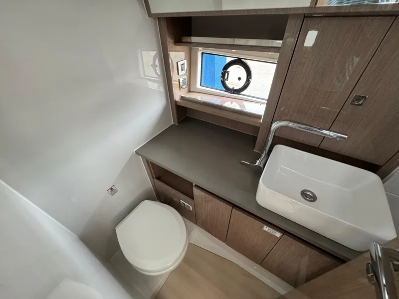 Slide: The Image of 2024 Sealine S335V yacht bathroom with modern sink, toilet, and wooden cabinetry. - 23
