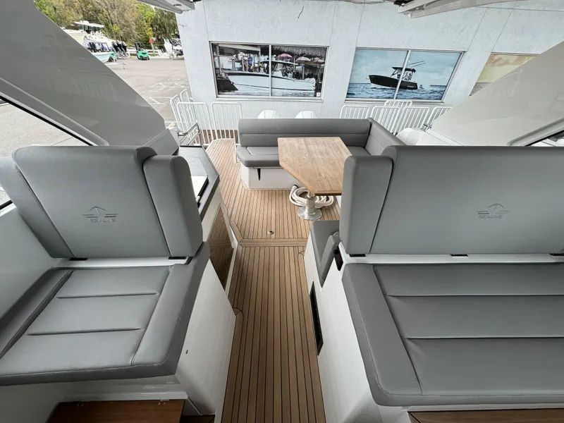 Slide: The Image of 2024 Sealine S335V yacht interior with gray seating and wooden flooring. - 28