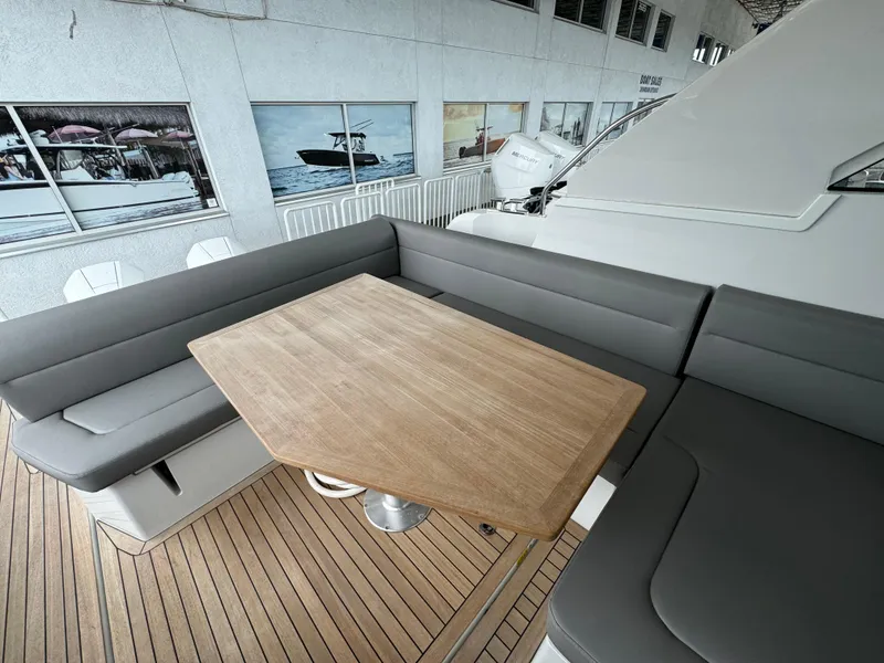 Slide: The Image of 2024 Sealine S335V yacht interior with wooden table and gray seating. - 31