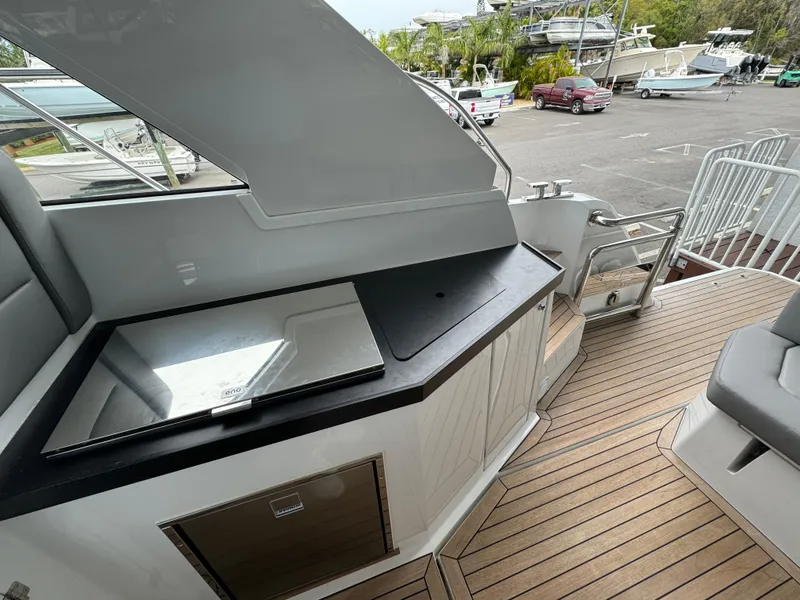 Slide: The Image of 2024 Sealine S335V yacht deck with sleek outdoor kitchen and seating area. - 32