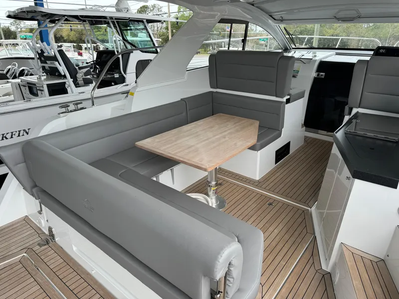 Slide: The Image of 2024 Sealine S335V yacht interior with gray seating and wooden table. - 7