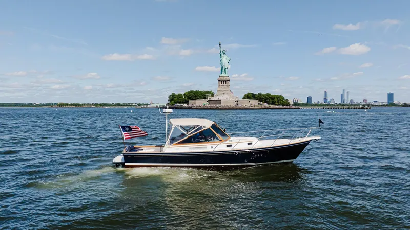 Slide: The Image of Little Harbor WhisperJet 38 boat near Statue of Liberty, 1998 model, sunny day. - 0