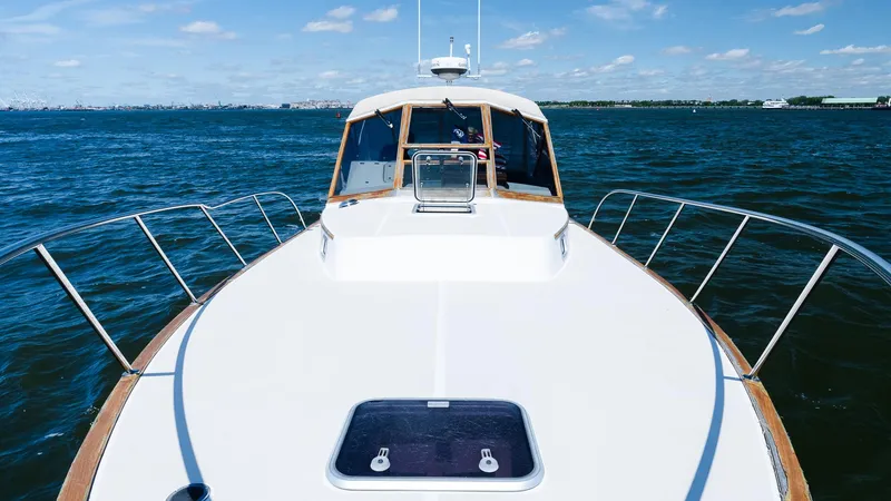 Slide: The Image of 1998 Little Harbor WhisperJet 38 yacht on open water, clear sky, and distant shoreline. - 10