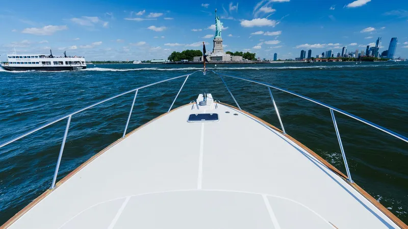 Slide: The Image of Bow of 1998 Little Harbor WhisperJet 38 approaching Statue of Liberty on sunny day. - 11