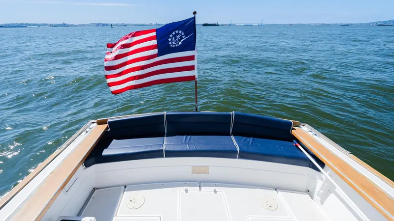 Slide: The Image of Little Harbor WhisperJet 38 boat with American flag on open water, 1998 model. - 12