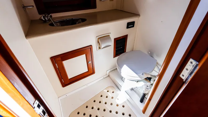 Slide: The Image of 1998 Little Harbor WhisperJet 38 bathroom with toilet, sink, and wooden accents. - 17