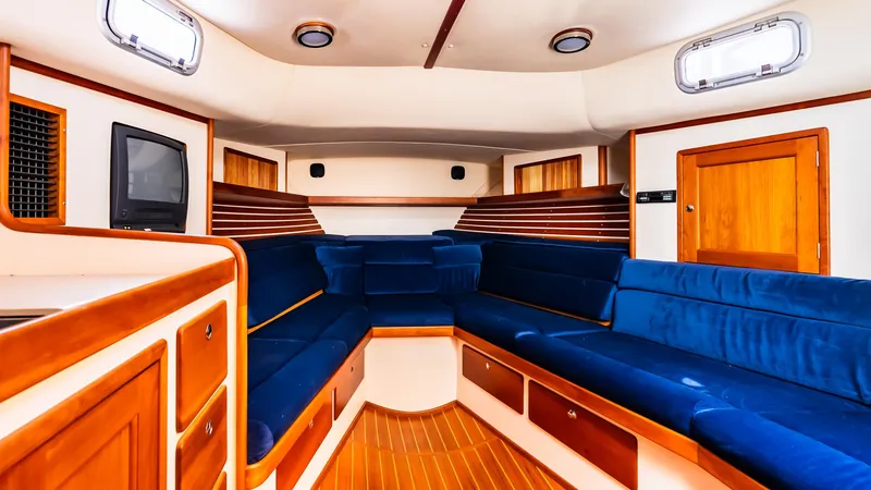Slide: The Image of Interior of 1998 Little Harbor WhisperJet 38, featuring blue seating and wooden accents. - 18
