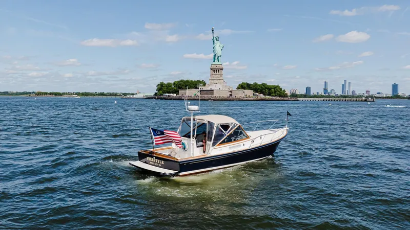 Slide: The Image of Little Harbor WhisperJet 38 boat near Statue of Liberty, 1998 model, sunny day. - 3