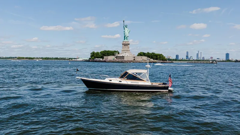Slide: The Image of Little Harbor WhisperJet 38 boat near Statue of Liberty, 1998 model, on a sunny day. - 4