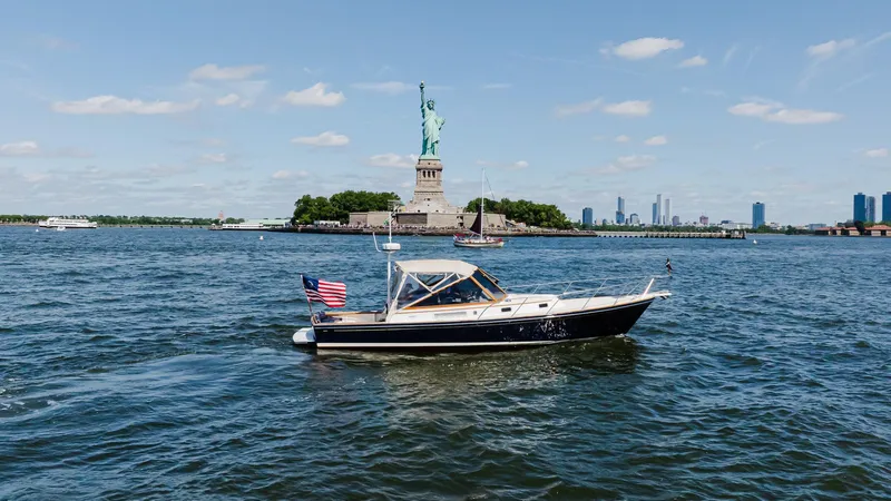 Slide: The Image of Little Harbor WhisperJet 38 boat near Statue of Liberty, 1998 model, on a sunny day. - 6