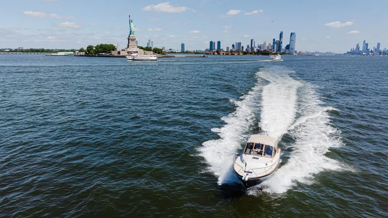 Slide: The Image of Little Harbor WhisperJet 38 cruising near Statue of Liberty, New York City skyline in background. - 7