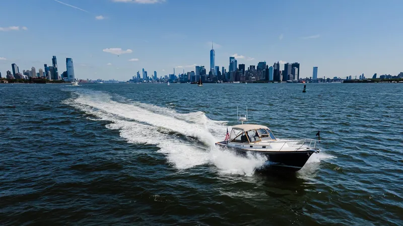 Slide: The Image of 1998 Little Harbor WhisperJet 38 cruising on water with city skyline in background. - 8